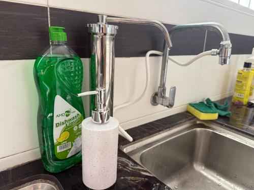 a kitchen sink with a bottle of cleaning agent next to it at Serenity Haven Family Stay Ipoh 10-12 Pax in Ipoh