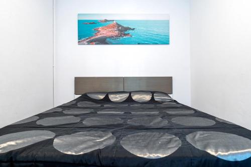 un lit dans une chambre avec un tableau sur le mur dans l'établissement Apartamento de playa, à La Playa
