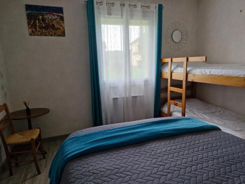 Un dormitorio con dos literas y una ventana. en Chambre d hotes dans maison au calme et bien située pour visiter de nombreux sites, en Saint-Pantaléon-de-Larche