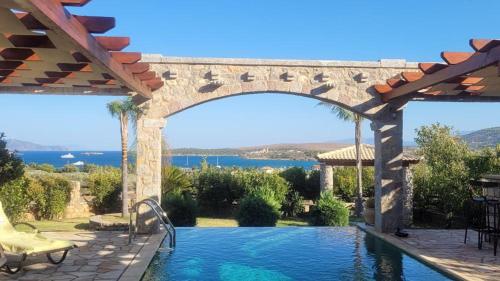 a swimming pool under a stone archway with a view at Villa with private pool and stunning sea view in Galaxidhion