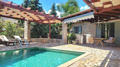 a patio with a swimming pool and a house at Villa with private pool and stunning sea view in Galaxidhion