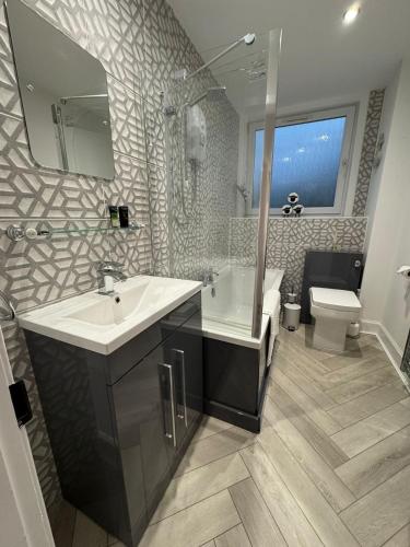 a bathroom with a sink and a tub and a toilet at Glenburn Cottage in Kirkmichael