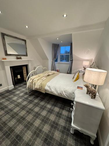a bedroom with a large bed and a fireplace at Glenburn Cottage in Kirkmichael