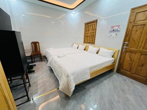 a bedroom with a large bed and a television at Nhà Nghỉ Hoàng Yến in Cái Răng