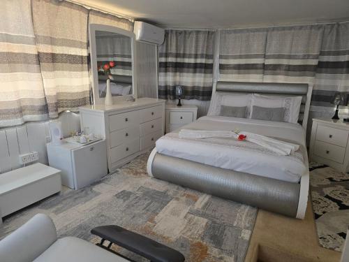 a bedroom with a large bed and a mirror at Apelles Palace Guest House - Staycation of choice - Home away from yours in Tlokweng