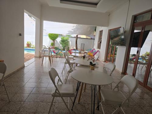 a room with tables and chairs and a pool at Apelles Palace Guest House - Staycation of choice - Home away from yours in Tlokweng