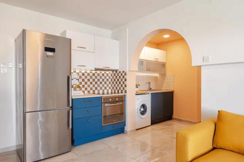 拉纳卡Kastella Blue Apartment Near Beach的厨房配有不锈钢冰箱和蓝色橱柜