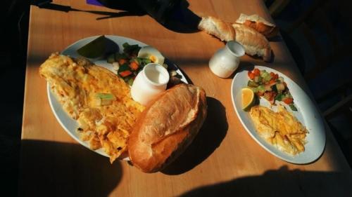 大叻Dalat Peace Backpackers Hostel的一张桌子,上面有两盘早餐食品