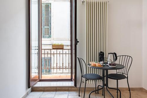 a table and chairs in a room with a balcony at Helios Vacanze in Conversano