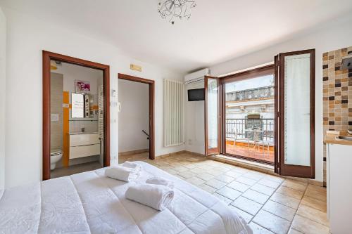 a bedroom with a large white bed and a large window at Helios Vacanze in Conversano