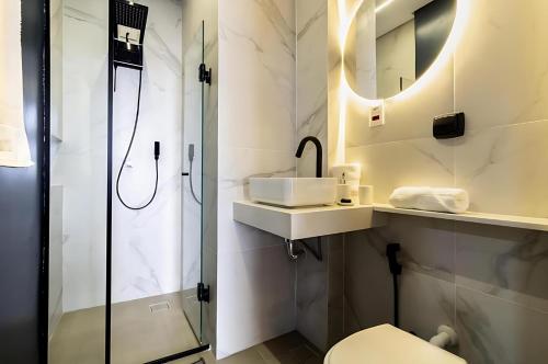 une salle de bains avec douche, lavabo et toilettes dans l'établissement Copan Castelli Studios SP, à São Paulo
