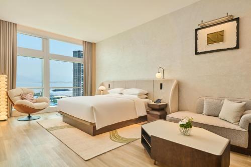 a bedroom with a bed and a living room at Doubletree By Hilton Shenzhen Bay in Shenzhen