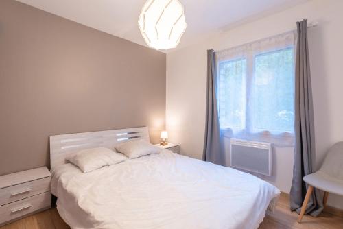 une chambre avec un lit blanc et une fenêtre dans l'établissement Chalets De L’arriutort 2 - Laruns, à Laruns