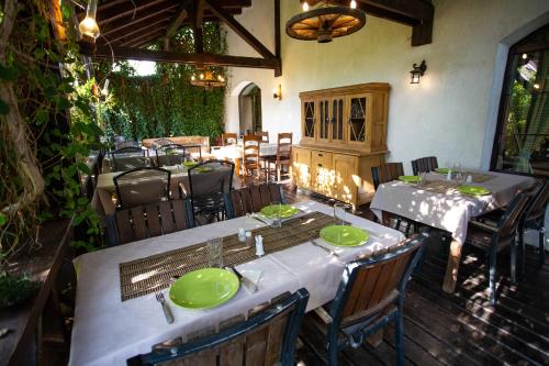 a restaurant with tables and chairs with green plates on them at Casa Mosului - Transfăgărășan Bed & Breakfast in Cîrţişoara