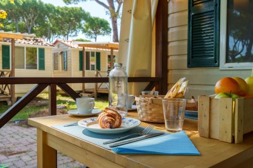 a wooden table with a plate of food on it at Massa Marina Camping in Marina di Massa