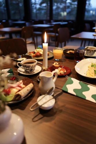 un tavolo di legno con una candela e piatti di cibo di Kelo Resort - northern lights and wilderness adventures in Kittilä a Raattama