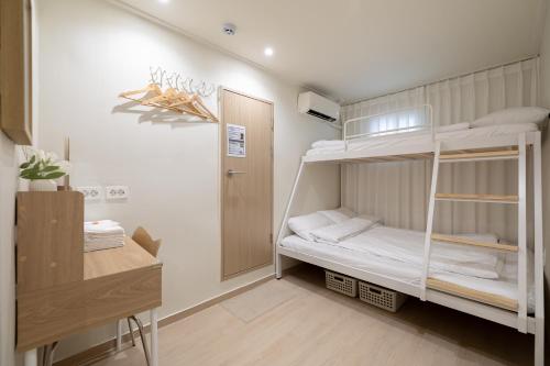 a room with two bunk beds and a desk at staysai 스테이사이 in Samgong