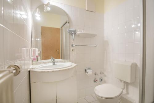 a white bathroom with a sink and a toilet at Stadt Aparthaus in Waren