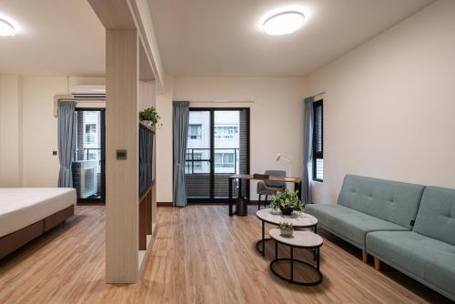 a room with a bed and a couch and a table at Water Woods Inn in Kaohsiung