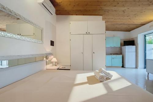 una habitación blanca con una cocina con armarios blancos en Villaggio Vacanza Baia Falcone, en Vieste