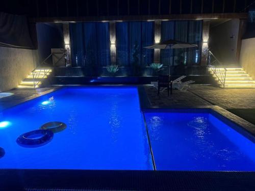 a swimming pool with blue lights in a room at Гостевой дом in Shymkent