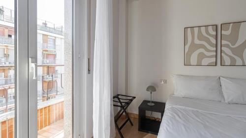 sypialnia z białym łóżkiem i oknem w obiekcie Italianway - Negroli 11 w Mediolanie