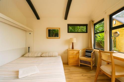 een slaapkamer met een bed, een bureau en een raam bij Nairobi Botanical Retreat - Container Home in Nairobi
