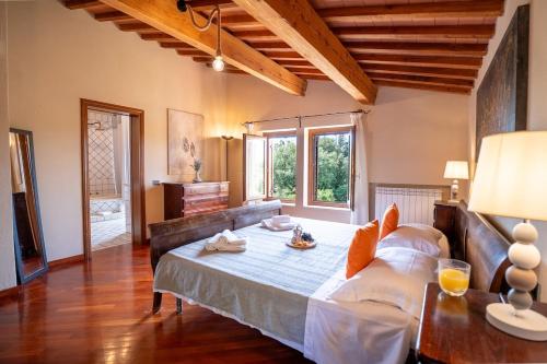 a living room with a large bed and a table at Pieve Vecchia, Luxury Tuscan Retreat with Spa in Campagnatico