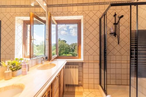 a bathroom with two sinks and a shower at Pieve Vecchia, Luxury Tuscan Retreat with Spa in Campagnatico