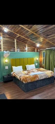 パハルガムにあるHotel crystalの緑の壁のベッドルーム1室(大型ベッド1台付)