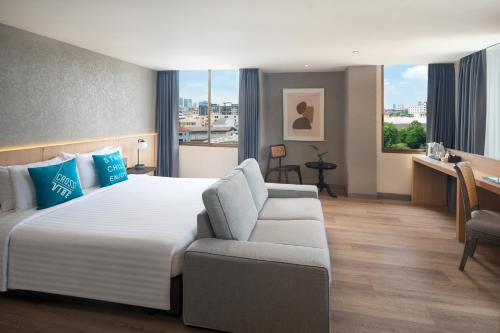 a hotel room with a bed and a couch at Cross Vibe Bangkok Srinakarin in Bangkok