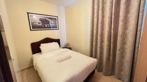 a small bedroom with a bed with white sheets at Frost Haven in Eldoret