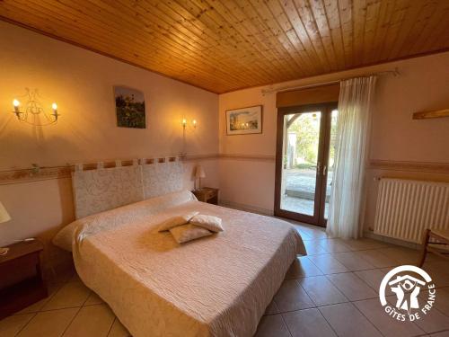a bedroom with a large bed and a window at Le gîte du Puech de Fons in Le Cayrol