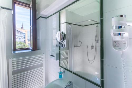 y baño con ducha y lavamanos. en Hotel Lunik en Praga