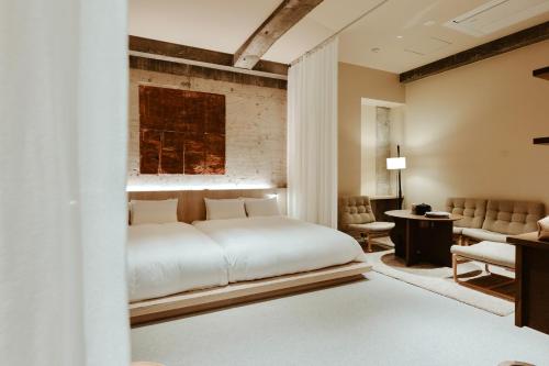 Un dormitorio con una cama blanca y una sala de estar. en mizuya, en Miyazu