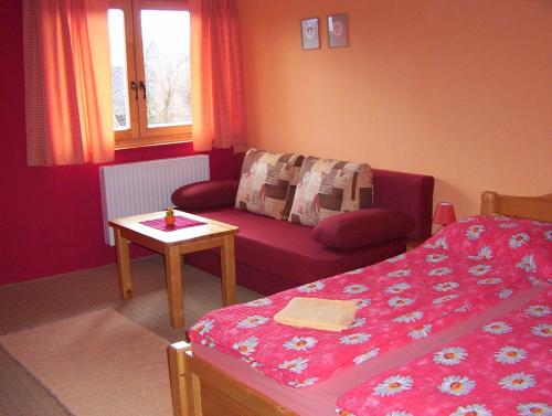 a bedroom with a bed and a couch and a table at Penzión Šindléry 533 in Partizánska ľupča