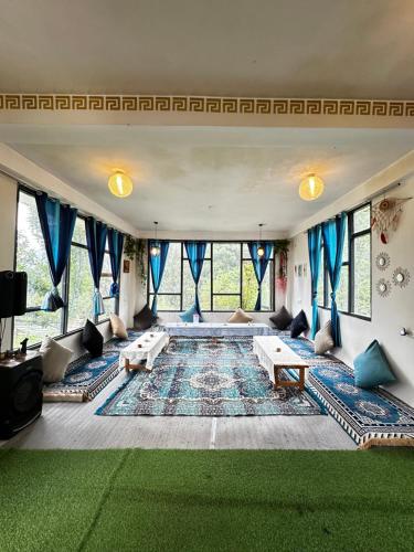 a living room with couches and a green rug at Rare House in Kalgha