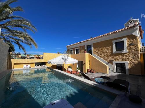 a house with a swimming pool next to a building at The Bellhouse Kranidi in Kranidi