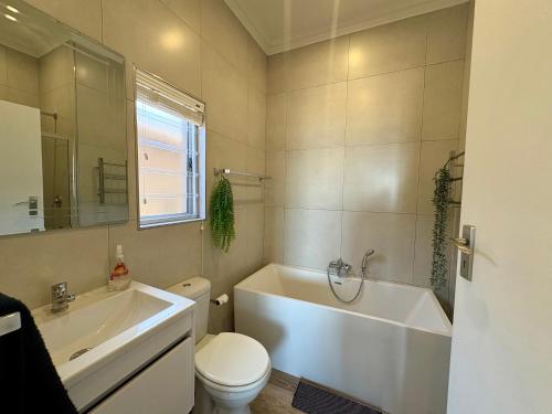 a bathroom with a tub and a toilet and a sink at Brenton-On-C-View in Brenton-on-Sea