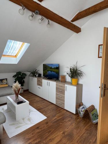 ein Wohnzimmer mit weißen Möbeln und einem Dachfenster in der Unterkunft Apartment Matasić self check-in and check-out in Otočac