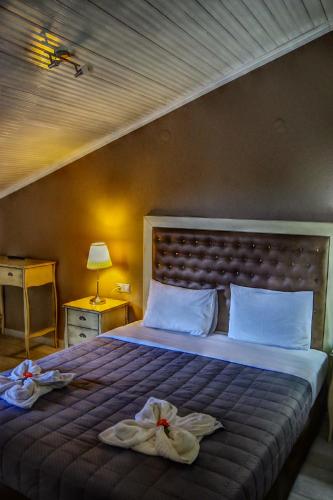a bedroom with a large bed with two towels on it at Rachoni Resort in Skala Rachoniou