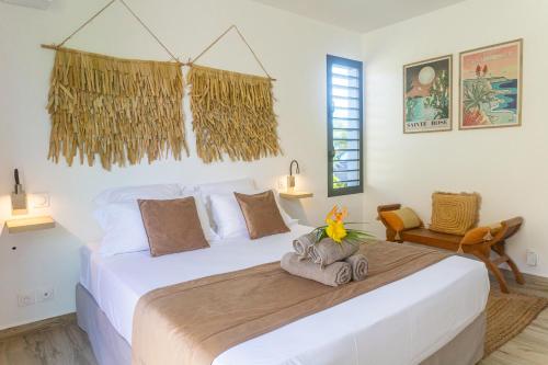 a bedroom with a large white bed in a room at Domaine Simini - Villas et Chalet entre mer et montagne in Sainte-Rose