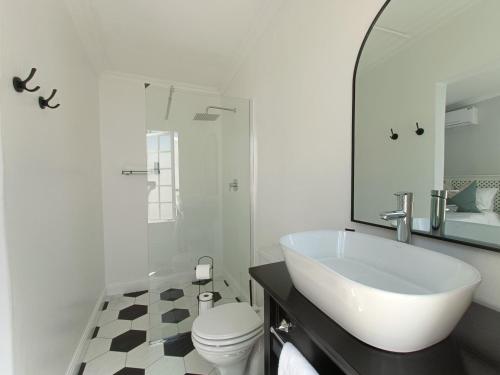 a white bathroom with a sink and a toilet at Bij De Graaff in Graaff-Reinet