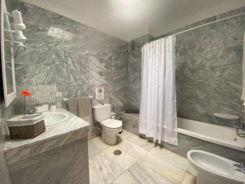 Un baño con inodoro, lavabo y ducha. en Apt. El Guirre Nº 13 - alto, en Playa Calera