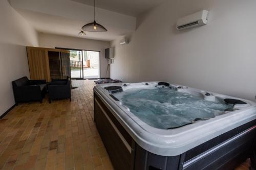 Saint-Lon-les-MinesにあるLa villa de saint lonのリビングルームに大きなジャクジータブが備わります。