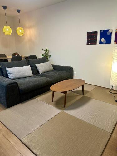 a living room with a couch and a coffee table at NK Comfort Villa BEPPU in Beppu
