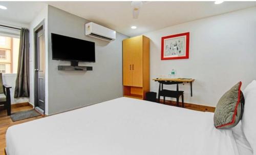 een hotelkamer met een groot bed en een televisie bij Townhouse Madhyamgram Chowmatha Bus Terminal Kolkata Formerly Star Guest House in Dohāri