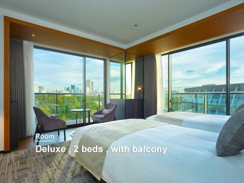 a hotel room with two beds and a balcony at Mitsui Garden Hotel Jingugaien Tokyo Premier in Tokyo