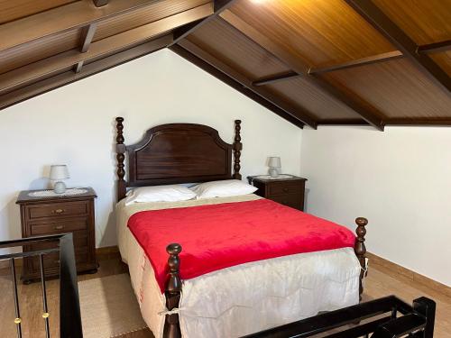 a bedroom with a bed with a red blanket at Vista Clara in Ponta do Sol