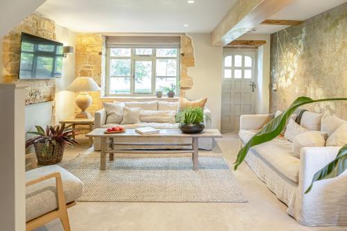 a living room with a couch and a table at Luxury Cotswold Retreats in Moreton in Marsh